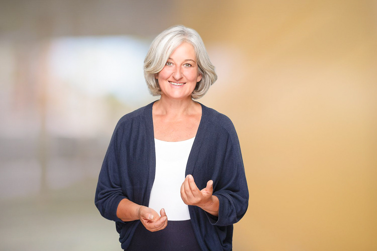 Businessportrait einer Frau in Führungsposition vor hellem Hintergrund